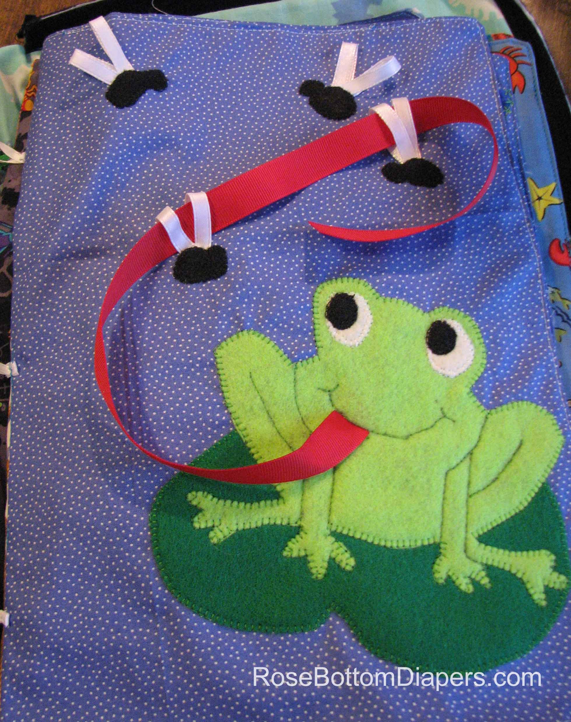 Feed the Frog quiet book page.  Cute way for toddlers to build motor skills.   Busy book ideas at RoseBottomDiapers.com